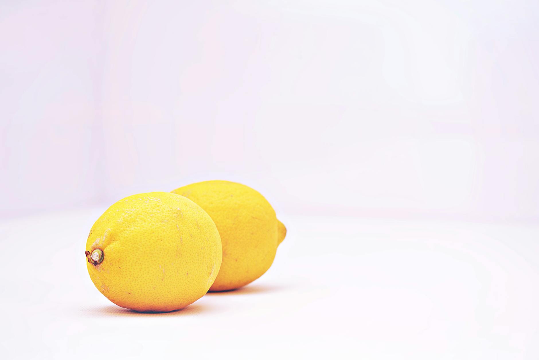 Yellow silicone vibrator surrounded by fresh peeled bananas on a bright yellow background