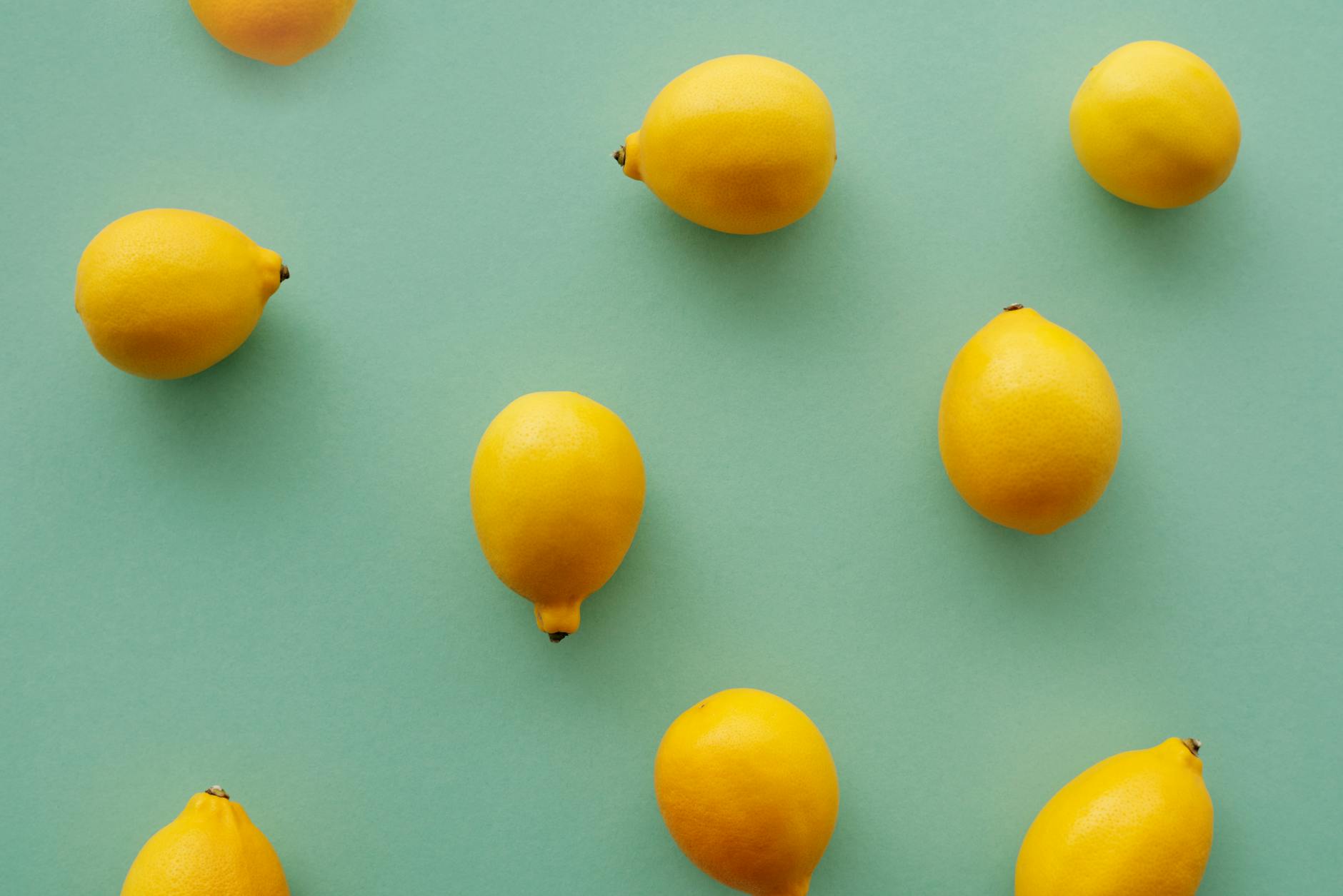 Bright yellow lemons arranged on a pastel green background, symbolizing freshness and vitality at any age