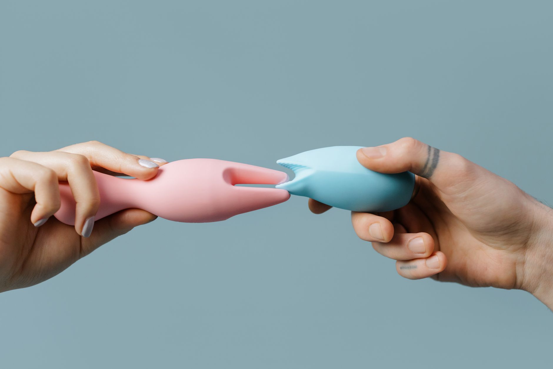 A blue silicone lemon sucker held in hand against a purple background