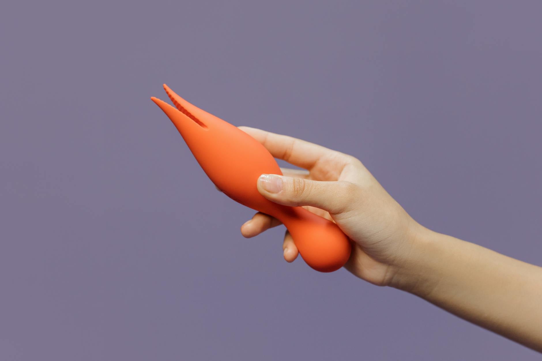 A couple standing together indoors, holding a vibrator, symbolizing modern intimacy and partnership.