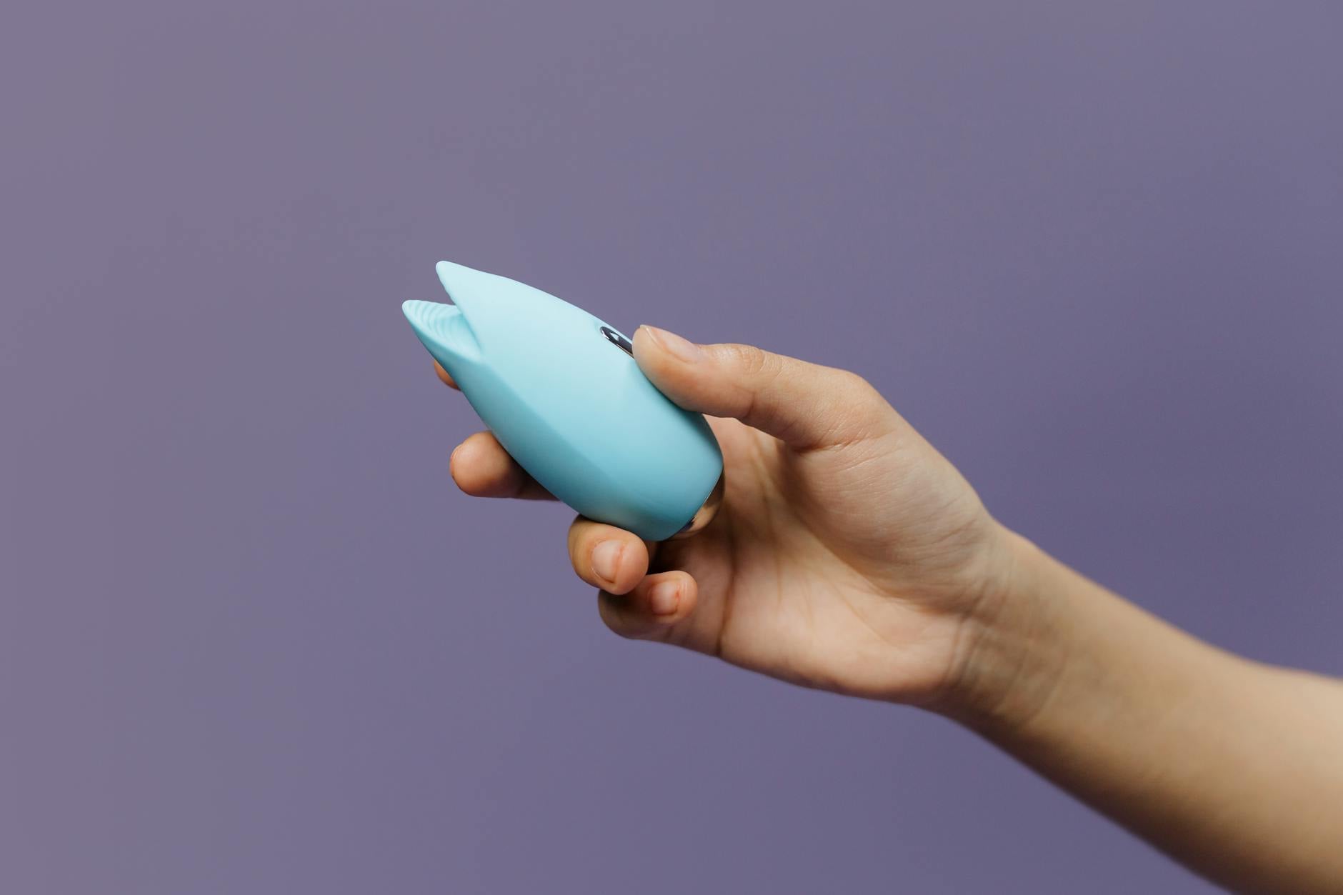 A couple holding a blue vibrator together, symbolizing modern intimacy and shared pleasure in a relationship