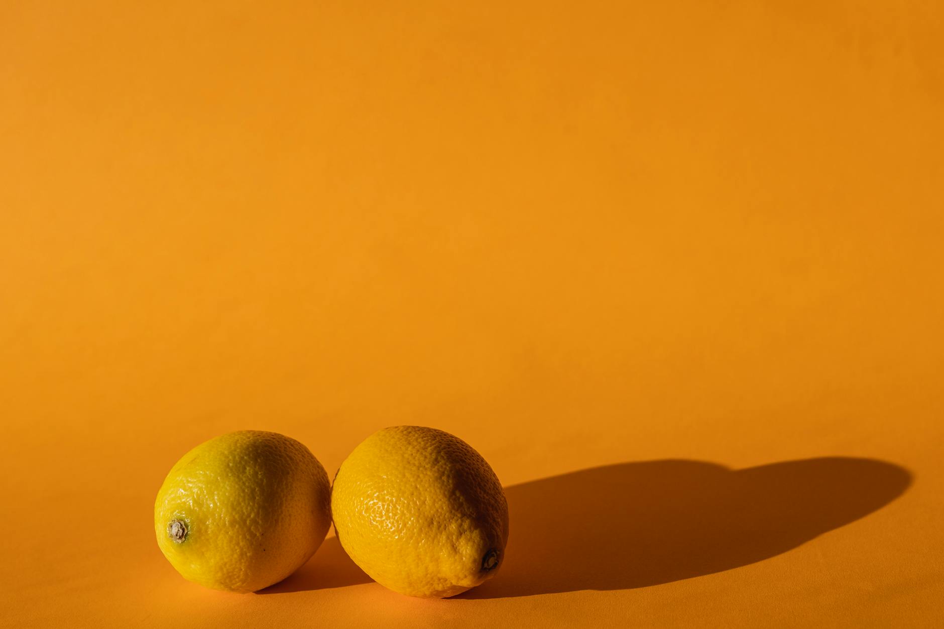 Fresh yellow lemons stacked with books on white cloth, symbolizing foundational pleasure building